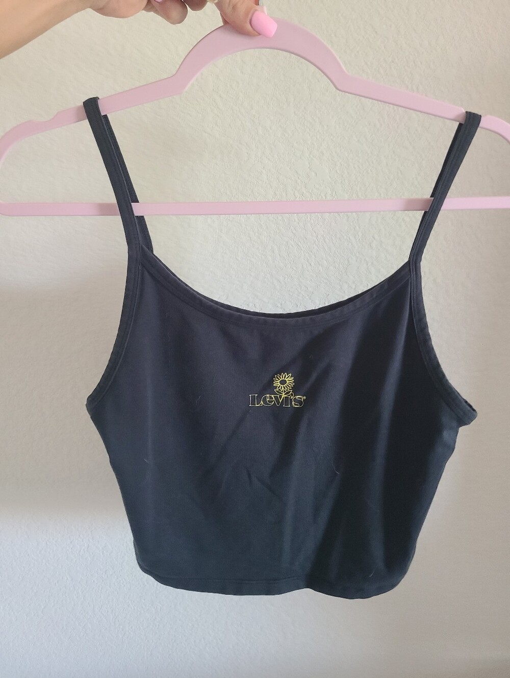 black Levi's graphic cami tank top featuring a small yellow sunflower logo